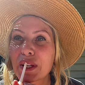 Person applying lip balm outdoors